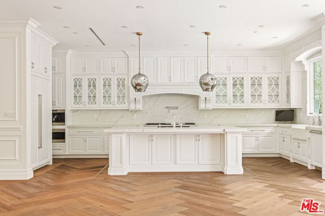a kitchen with stainless steel appliances granite countertop a white cabinets and wooden floor