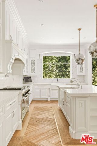 a large kitchen with granite countertop a stove and a sink