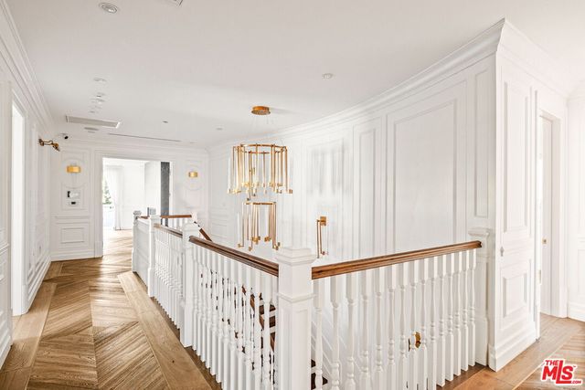 a view of a hallway with wooden floor and windows
