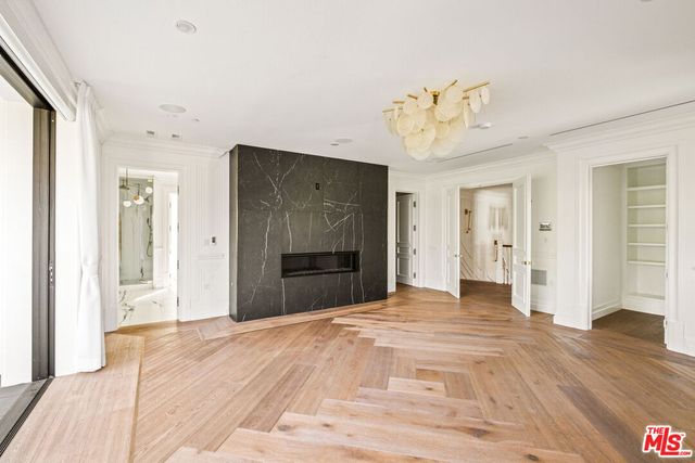 a view of a livingroom with a chandelier fan and wooden floor