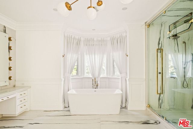a white bath tub sitting next to a bathroom sink
