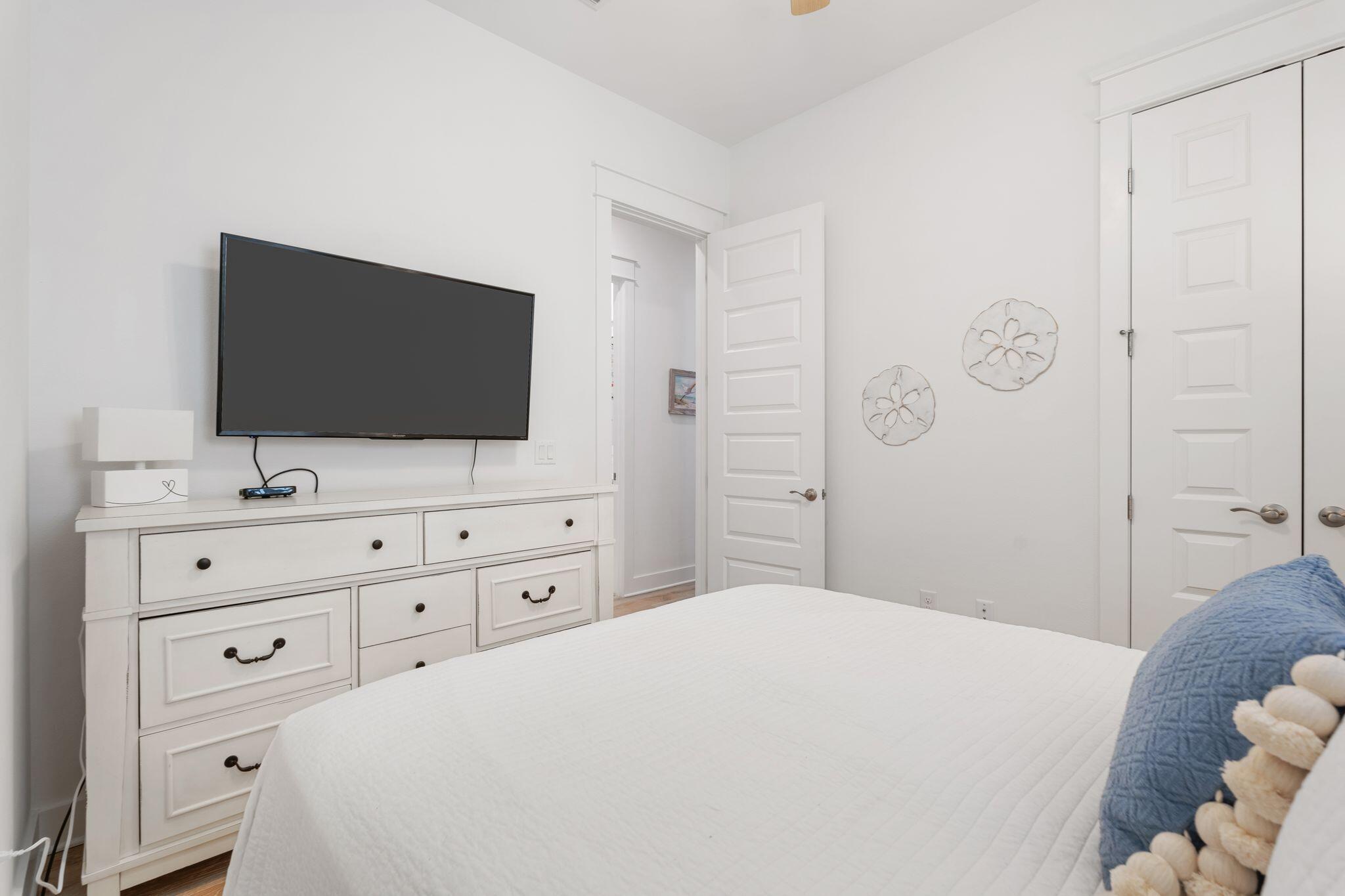 111 Pine Lands Loop East, Unit A Inlet Beach, FL 32461 - Photo 25 of 54 a bedroom with a bed and a flat screen tv in white walls