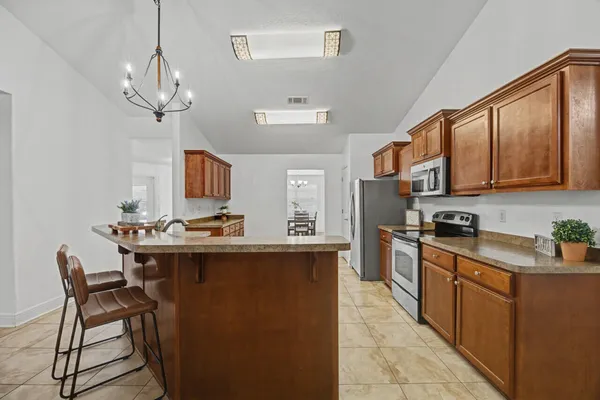 a kitchen with stainless steel appliances a sink stove and cabinets