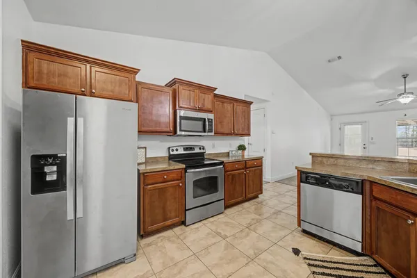 a kitchen with stainless steel appliances granite countertop a refrigerator stove and sink