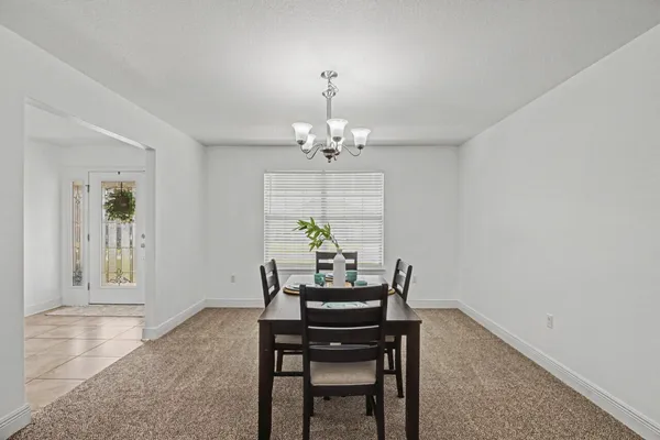 a view of a dining room with furniture and chandelier