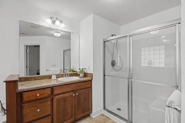 a spacious bathroom with a granite countertop sink a toilet mirror and bathtub