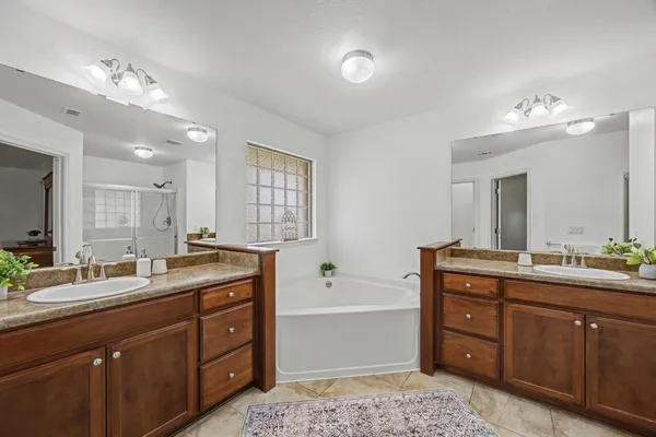 a bathroom with a granite countertop sink a large mirror and a bathtub