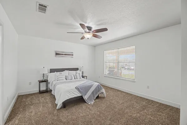 a bedroom with a large bed and a chandelier