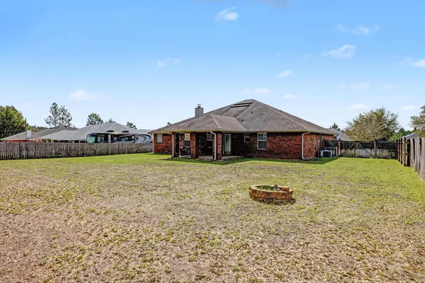 a view of a house with roof and tall trees