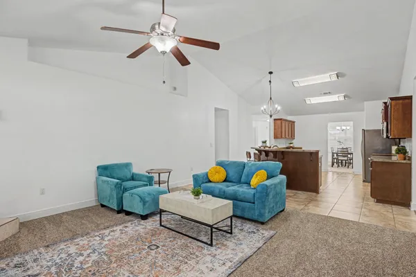 a living room with furniture and kitchen view