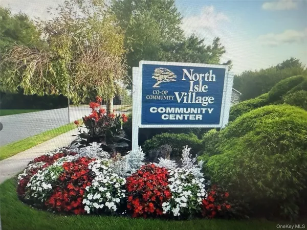 a view of a sign board with yard and green space
