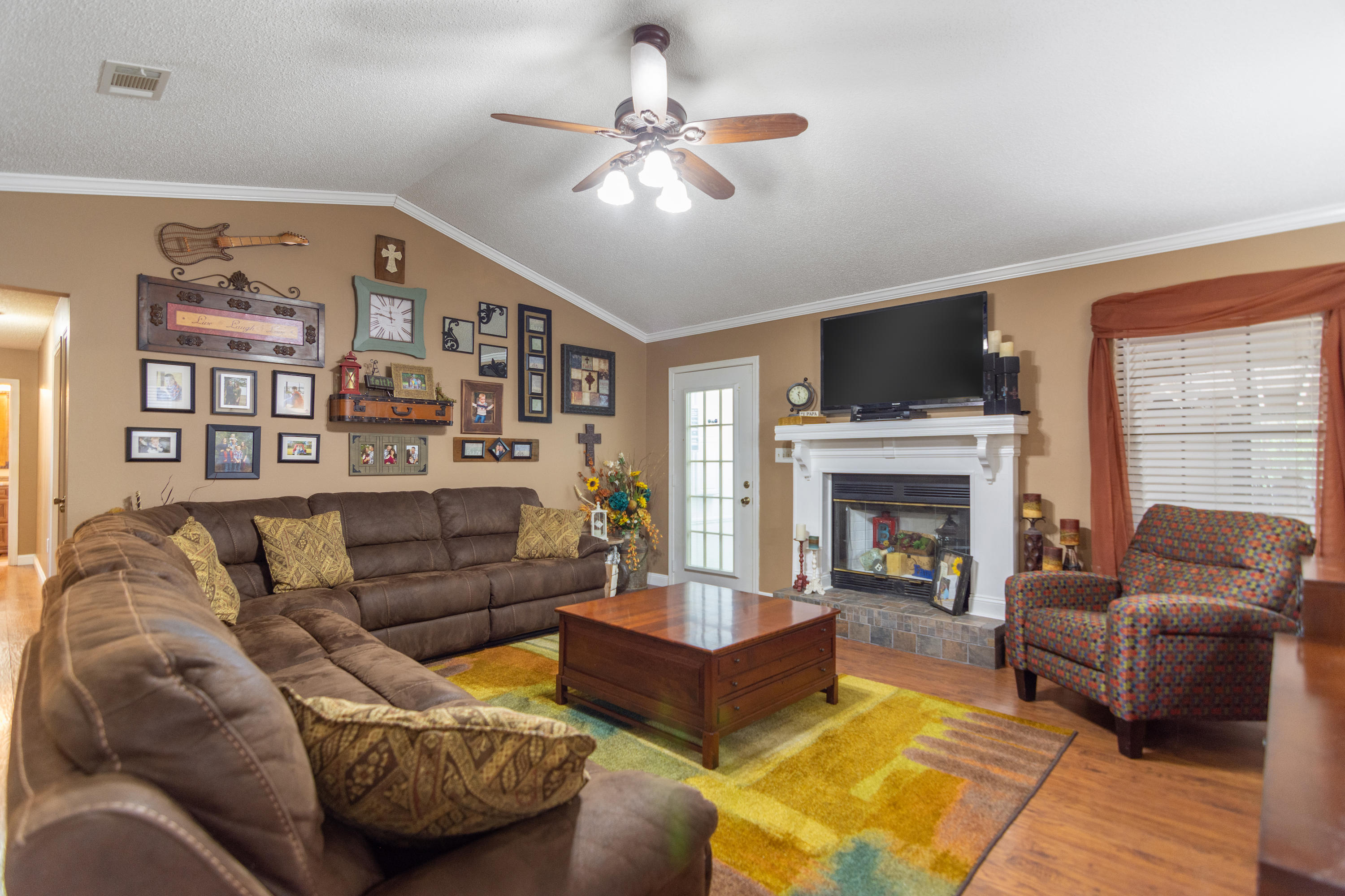 5551 Buckward Road Baker, FL 32531 - Photo 11 of 47 a living room with furniture fireplace and a flat screen tv