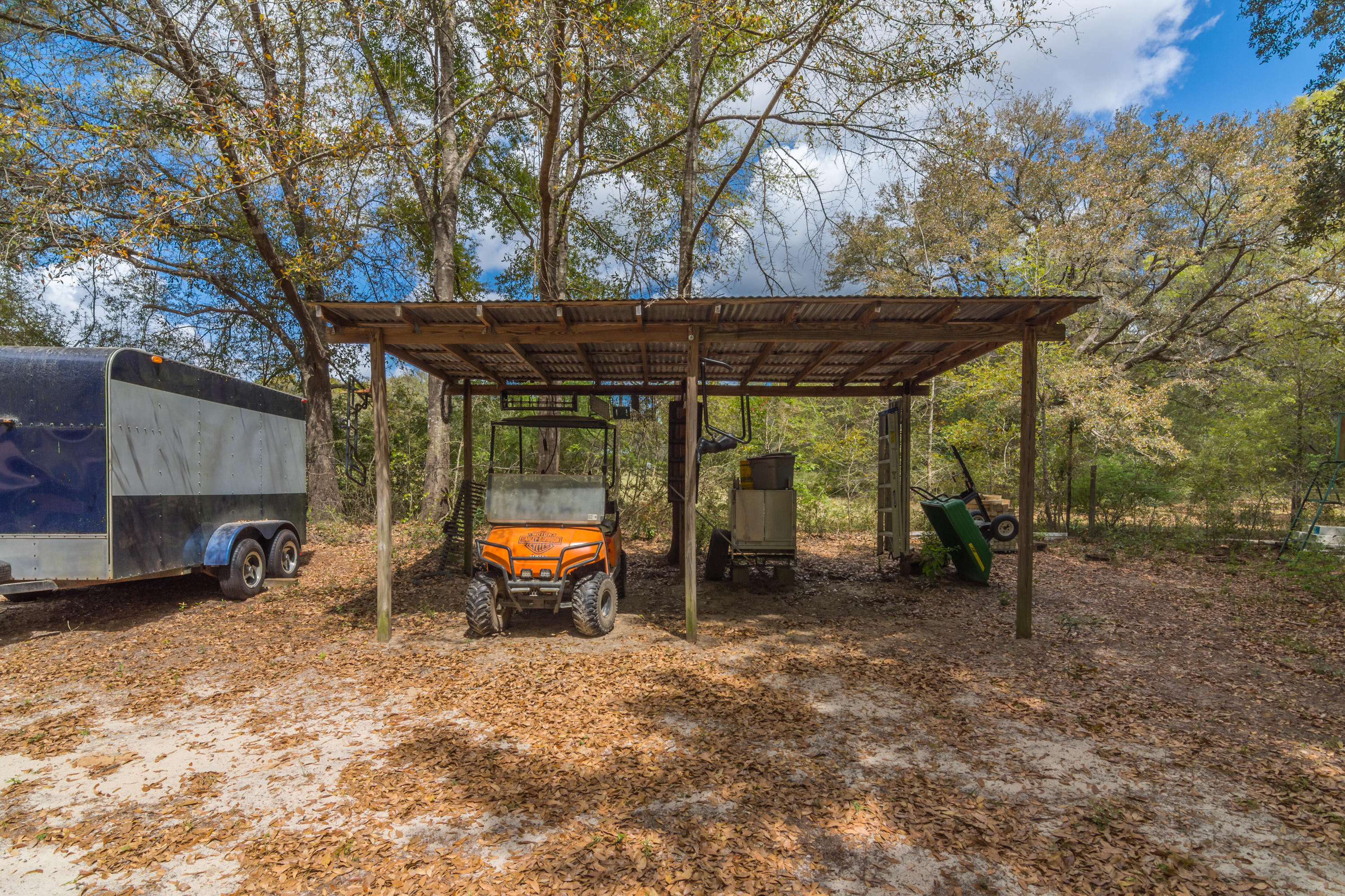 5551 Buckward Road Baker, FL 32531 - Photo 7 of 47 a view of a patio with a table and chairs under an umbrella with large trees
