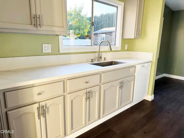 a kitchen with white cabinets and white appliances