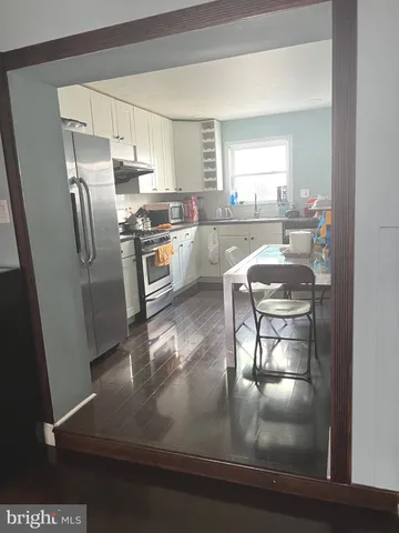 a kitchen with kitchen island a counter top space a sink stainless steel appliances and cabinets