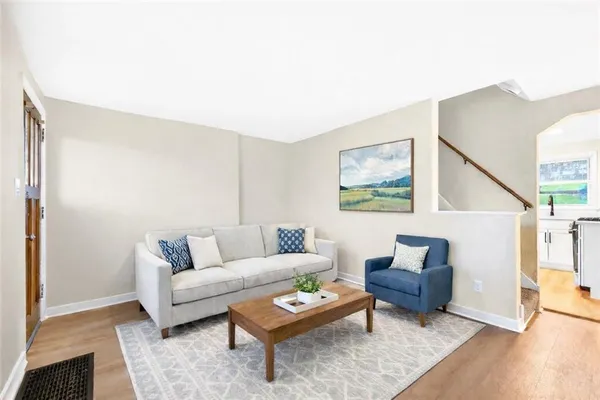 a living room with furniture and a wooden floor