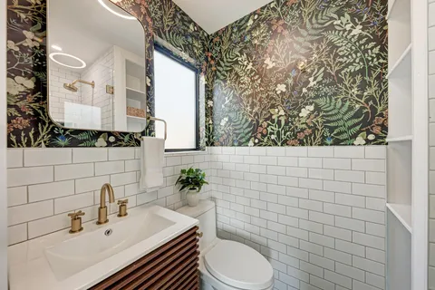 a bathroom with a sink a toilet and mirror