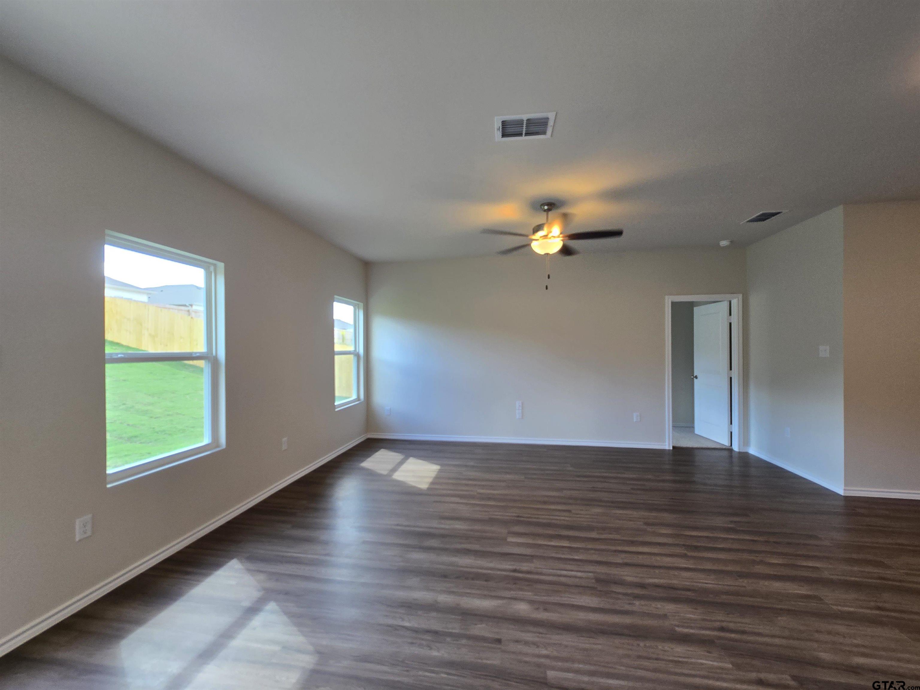 324 Erica Way Lindale, TX 75771 - Photo 6 of 14 a view of an empty room with window and wooden floor