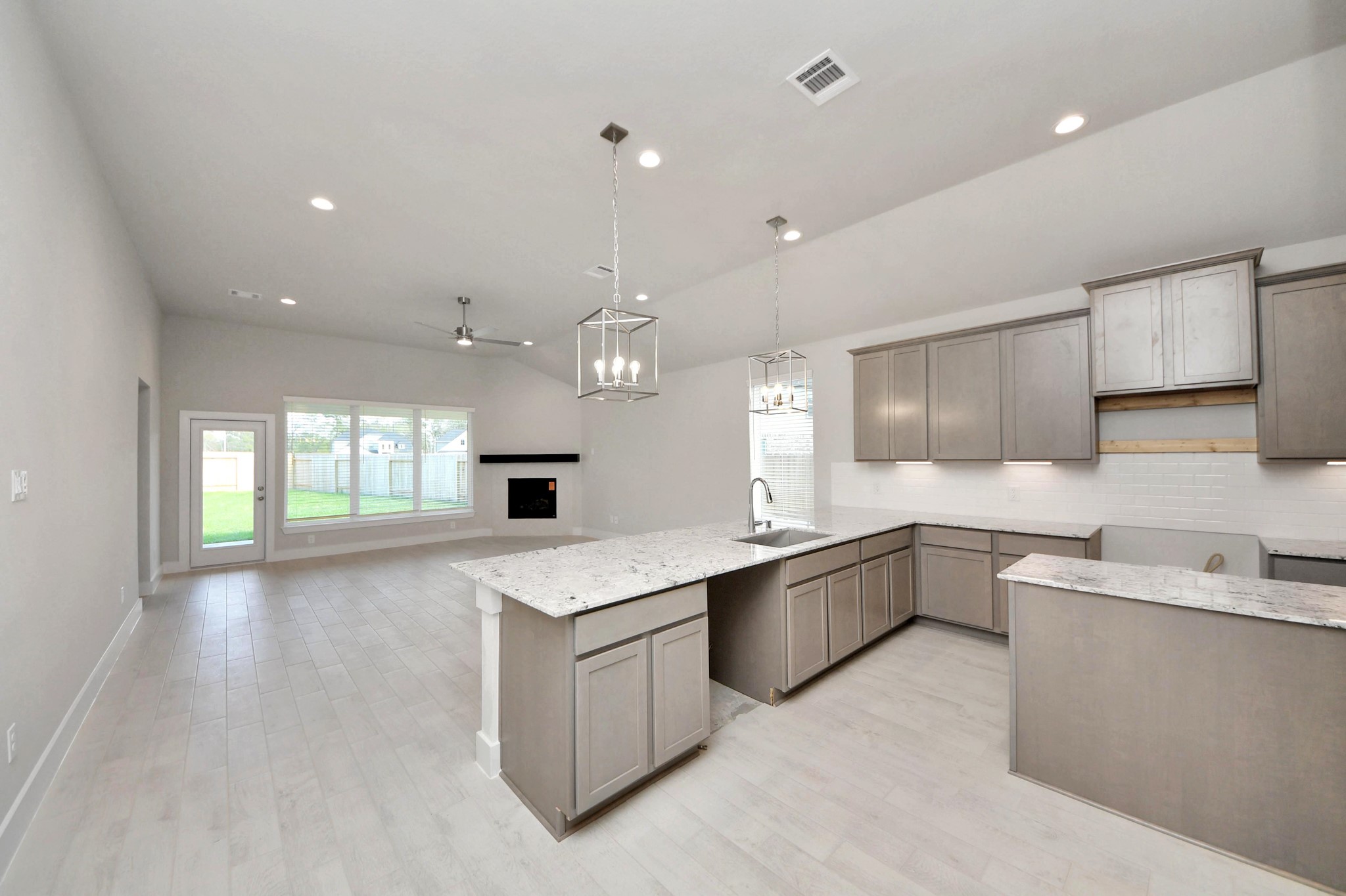 3042 Native Spg Drive Spring, TX 77373 - Photo 13 of 32 Step into a dream realized with this generously spacious kitchen! A massive granite island takes center stage, complemented by high ceilings and soft-close cabinets. The granite countertops, stainless steel appliances, sleek tile backsplash, and recessed lighting complete the elegant design. Sample photo of completed home with similar floor plan. Actual colors and selections may vary.
