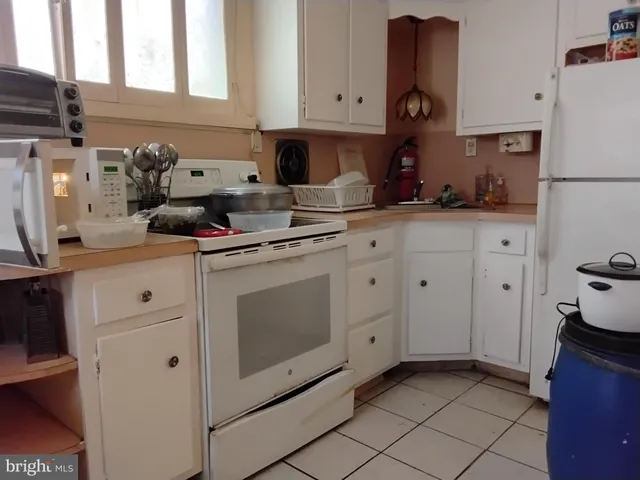 a kitchen with white cabinets and white appliances
