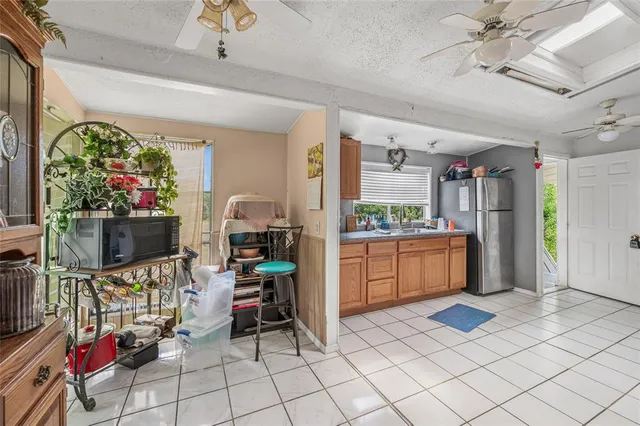 a kitchen with stainless steel appliances kitchen island granite countertop a refrigerator and a sink