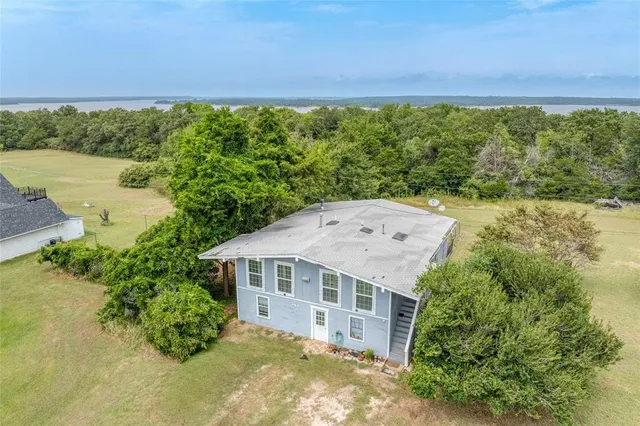 an aerial view of a house with a yard and lake view