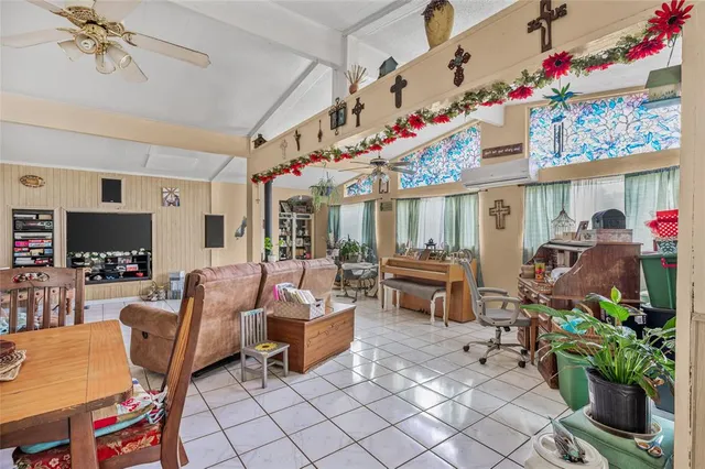 a living room with furniture a flat screen tv and a floor to ceiling window