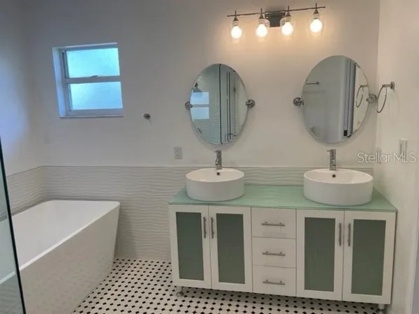 a bathroom with 2 sink and a mirror