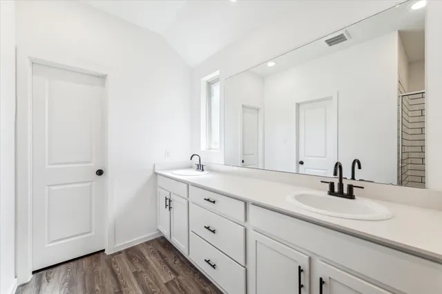 a bathroom with a double vanity sink and mirror