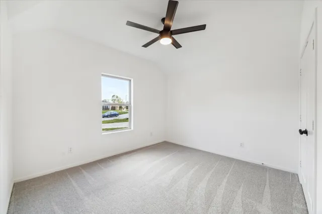an empty room with a window and a ceiling fan