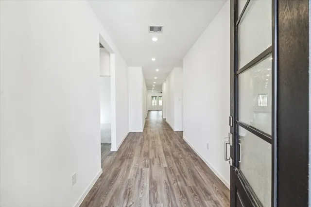 a view of a hallway with wooden floor