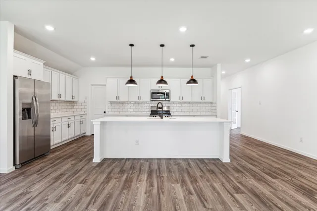 a view of kitchen center island wooden cabinets and stainless steel appliances