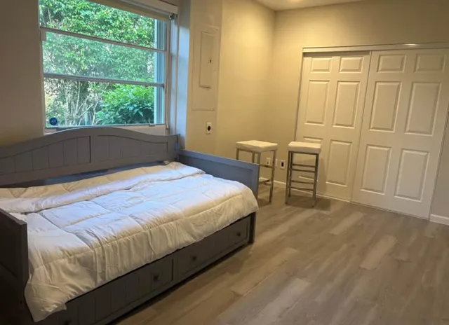 a bedroom with a bed table and a window