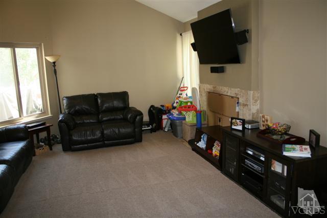 1706 Sinaloa Road, Unit 208 Simi Valley, CA 93065 - Photo 3 of 21 a living room with furniture a flat screen tv and a fireplace