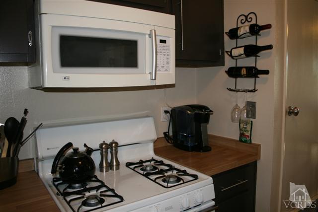 1706 Sinaloa Road, Unit 208 Simi Valley, CA 93065 - Photo 9 of 21 a kitchen with a stove and a microwave