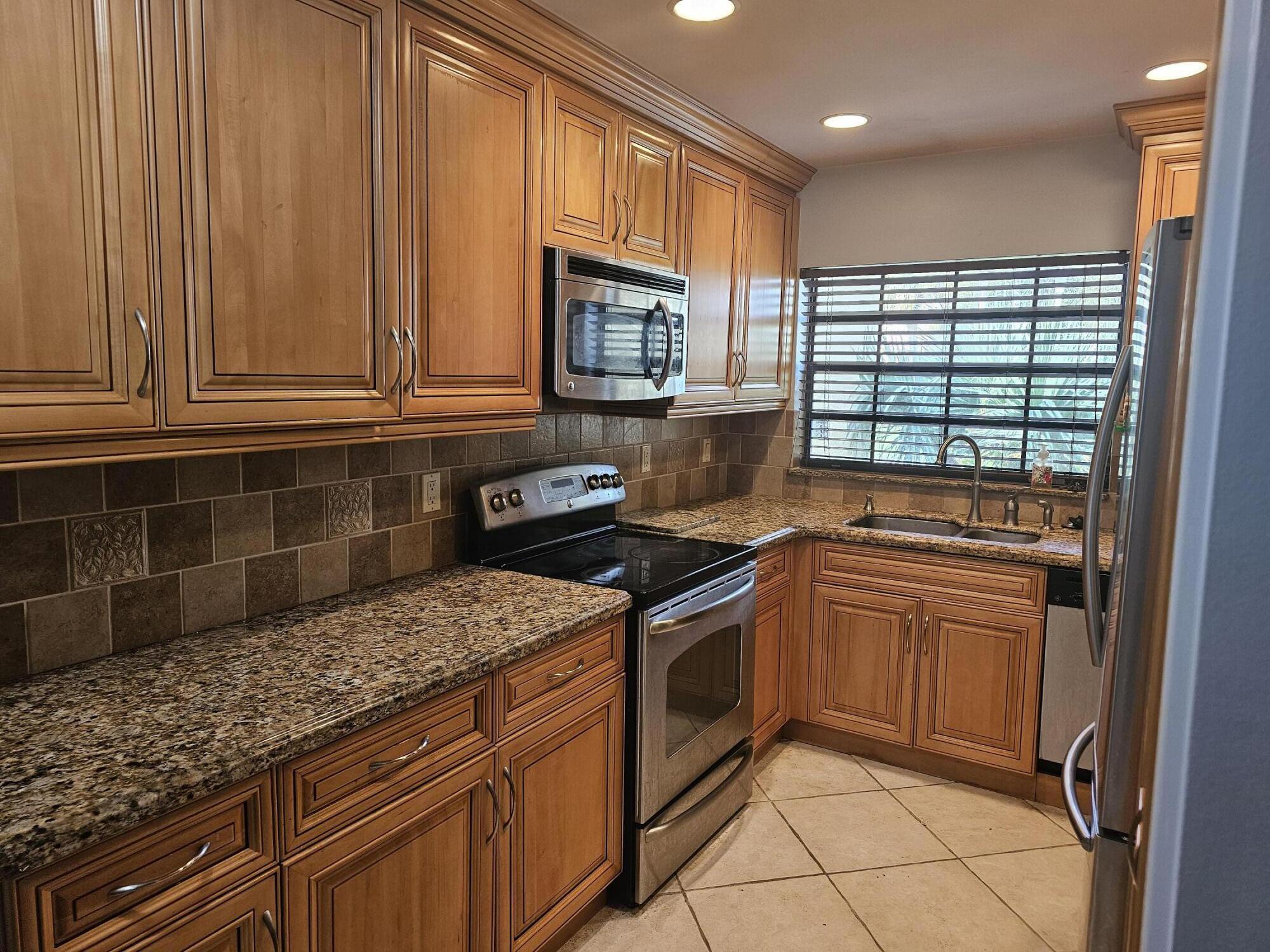 a kitchen with granite countertop cabinets stainless steel appliances and a counter space