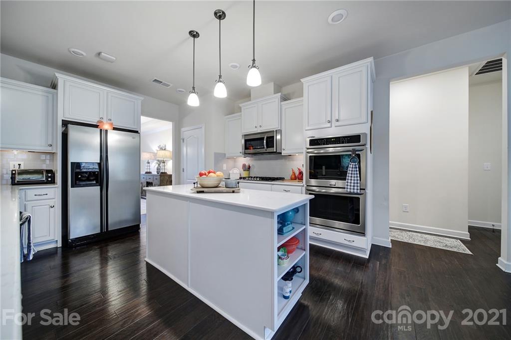 1004 Lightwood Road Waxhaw, NC 28173 - Photo 14 of 48 a kitchen with stainless steel appliances a stove a refrigerator a sink a center island and wooden floor