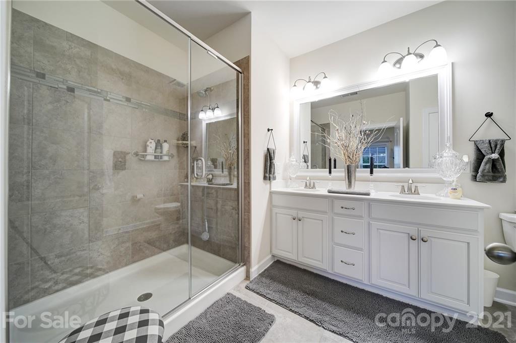 1004 Lightwood Road Waxhaw, NC 28173 - Photo 21 of 48 a bathroom with a shower a sink and a mirror