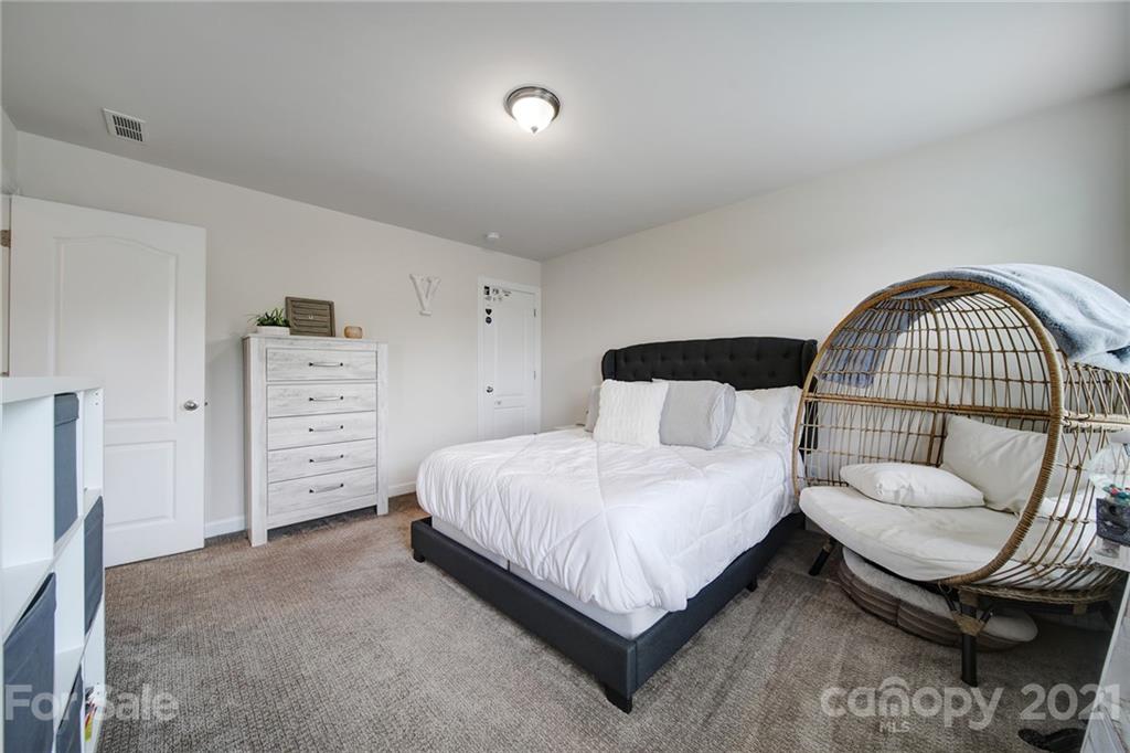1004 Lightwood Road Waxhaw, NC 28173 - Photo 30 of 48 a bedroom with a bed a mirror and dresser