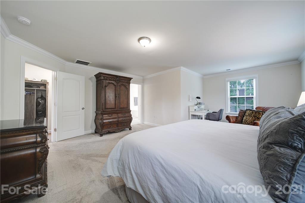 1004 Lightwood Road Waxhaw, NC 28173 - Photo 33 of 48 a spacious bedroom with a bed and dresser with mirror