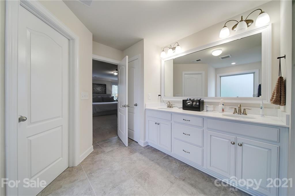 1004 Lightwood Road Waxhaw, NC 28173 - Photo 35 of 48 a spacious bathroom with a granite countertop sink mirror and a