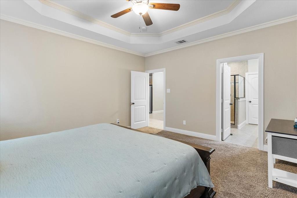 502 Ritchey Street Gainesville, TX 76240 - Photo 21 of 29 a bedroom with a bed and a chandelier