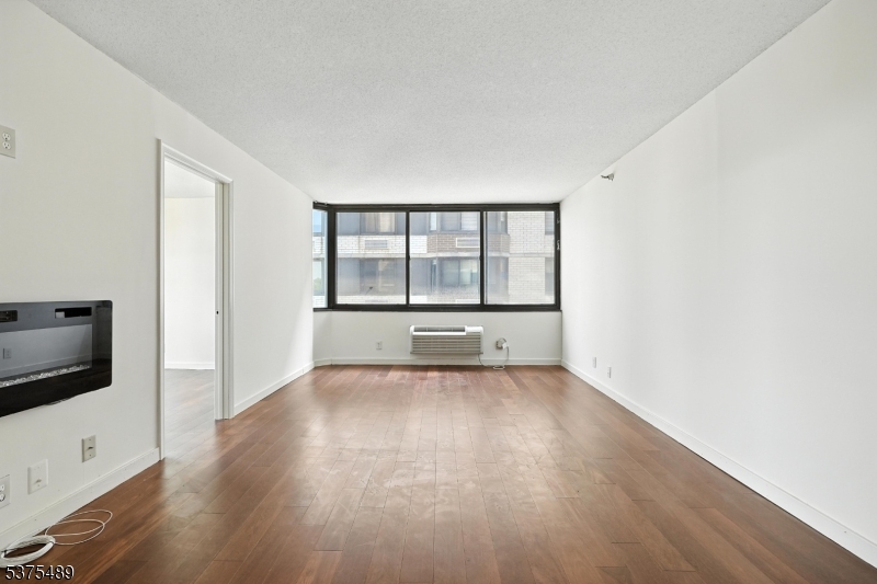 316 Prospect Avenue, Unit A Hackensack, NJ 07601 - Photo 12 of 18 an empty room with wooden floor and windows