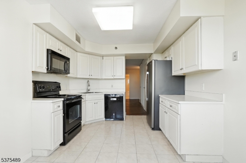 316 Prospect Avenue, Unit A Hackensack, NJ 07601 - Photo 14 of 18 a kitchen with stainless steel appliances granite countertop a stove top oven a sink and a refrigerator