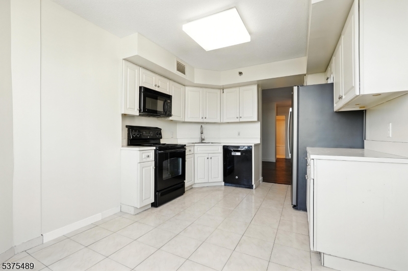 316 Prospect Avenue, Unit A Hackensack, NJ 07601 - Photo 15 of 18 a kitchen with a stove top oven and refrigerator