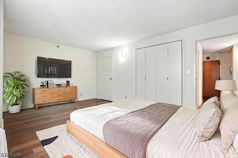 316 Prospect Avenue, Unit A Hackensack, NJ 07601 - Photo 2 of 18 a bedroom with a bed and a flat screen tv