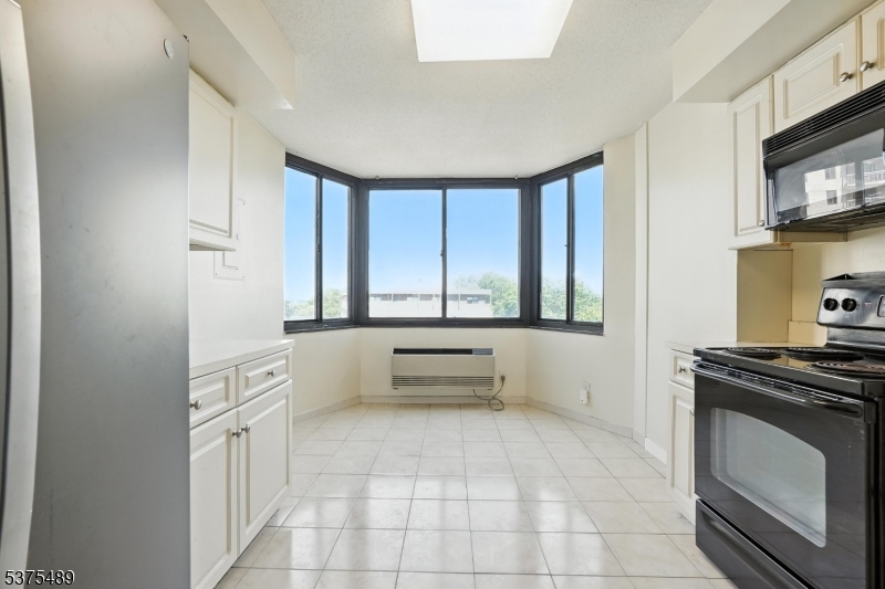 316 Prospect Avenue, Unit A Hackensack, NJ 07601 - Photo 5 of 18 a large white kitchen with a stove top oven