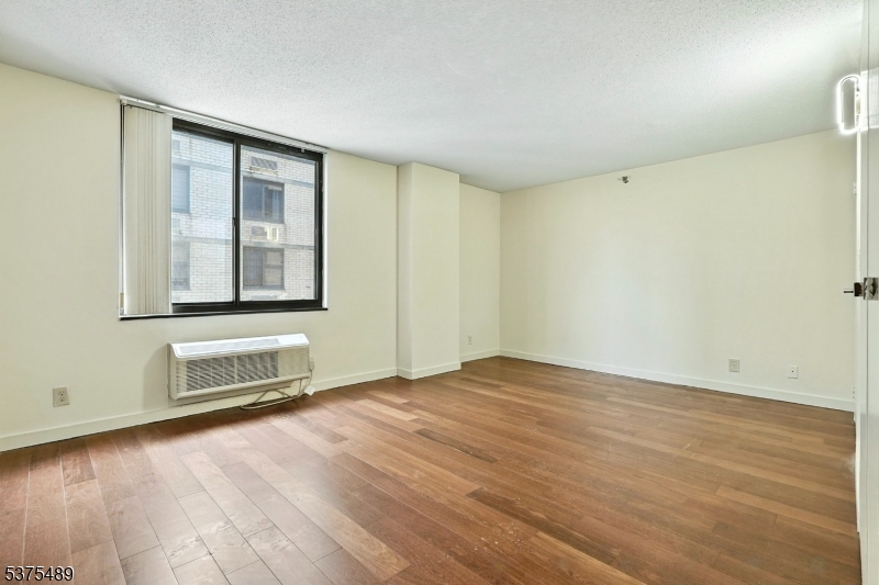 316 Prospect Avenue, Unit A Hackensack, NJ 07601 - Photo 6 of 18 an empty room with wooden floor and windows