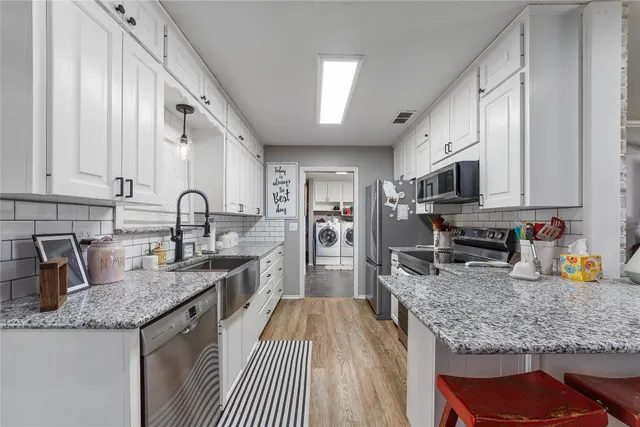 a kitchen with stainless steel appliances granite countertop a sink stove and refrigerator