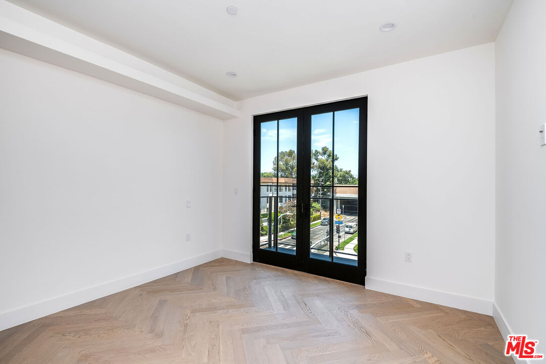 10352 Riverside Drive, Unit 301 Toluca Lake, CA 91602 - Photo 13 of 19 an empty room with wooden floor and windows
